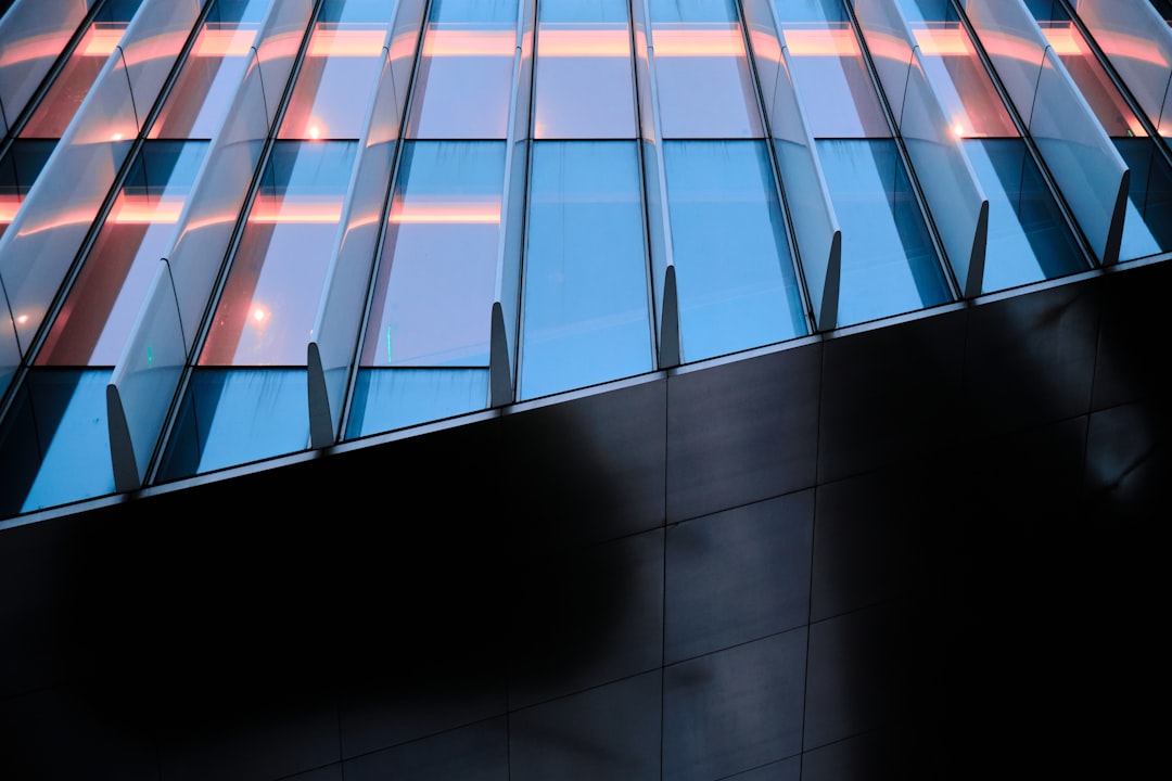 The sun reflects brightly off the clean, geometric facade of a modern glass skyscraper, symbolizing corporate excellence and a forward-thinking approach.