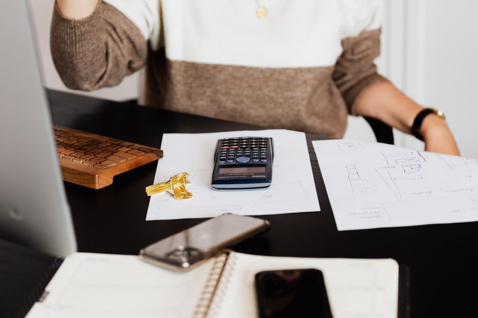A minimalist flat lay of modern house keys and a sleek calculator on a clean white desk, representing the new, data-backed financial models in real estate.