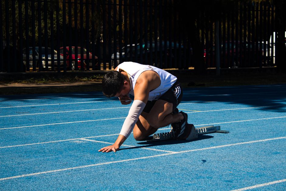 Three runners poised at the starting blocks of a race track, symbolizing the competitive comparison and 'showdown' of different link building approaches.